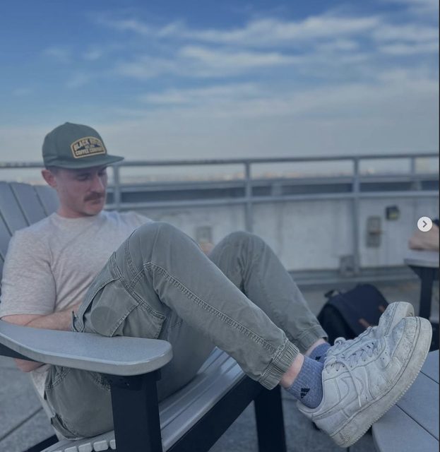 Sean sitting in a chair on a rooftop at dusk
